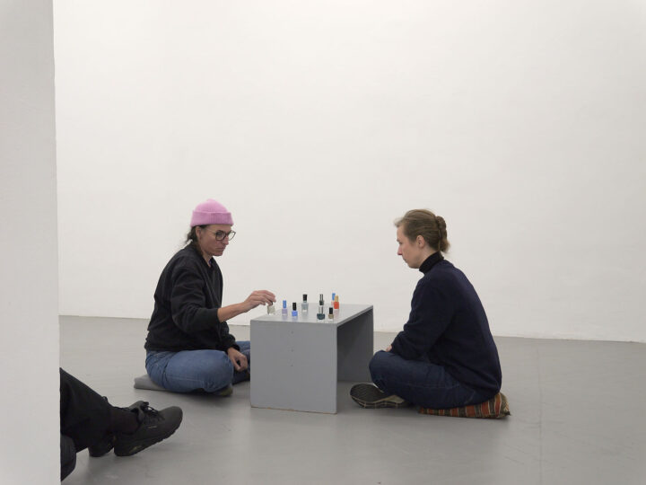 zwei Personen spielen Schach mit Nagellackfläschchen im Frise-Ausstellungsraum