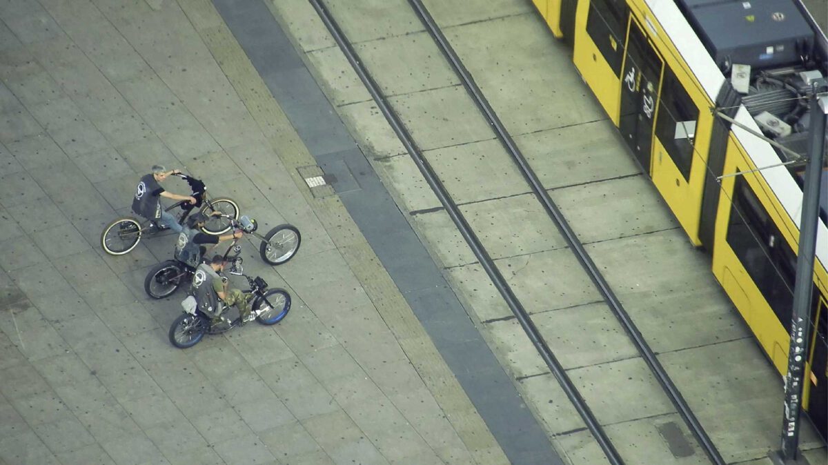 das Foto zeigt drei Biker und eine Straßenbahn im Anschnitt